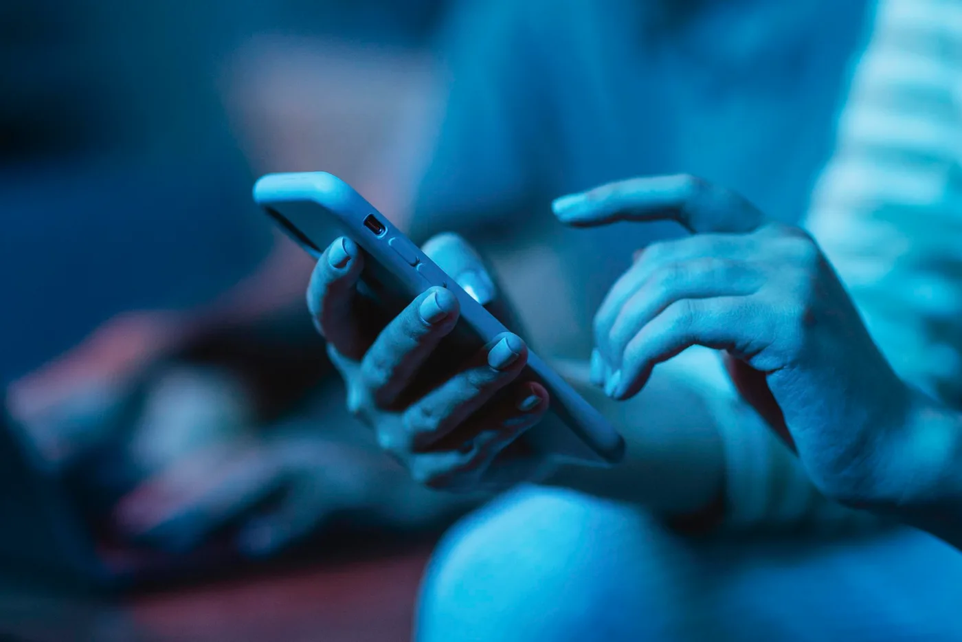 Pessoa usando o celular em casa, conectada na internet fibra da IAÇU NET